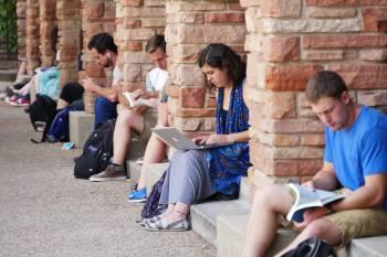 students studying outside on steps